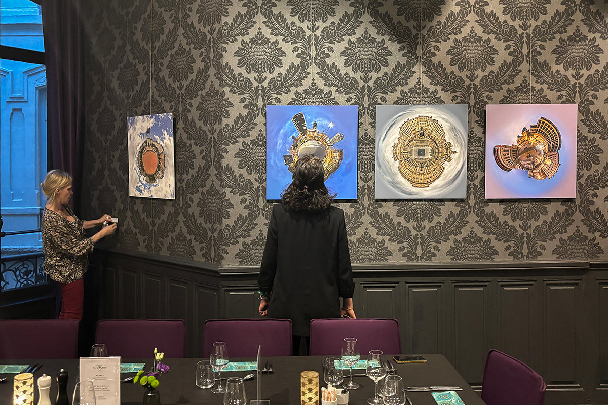Two people in a room with decorative wall art and a table.