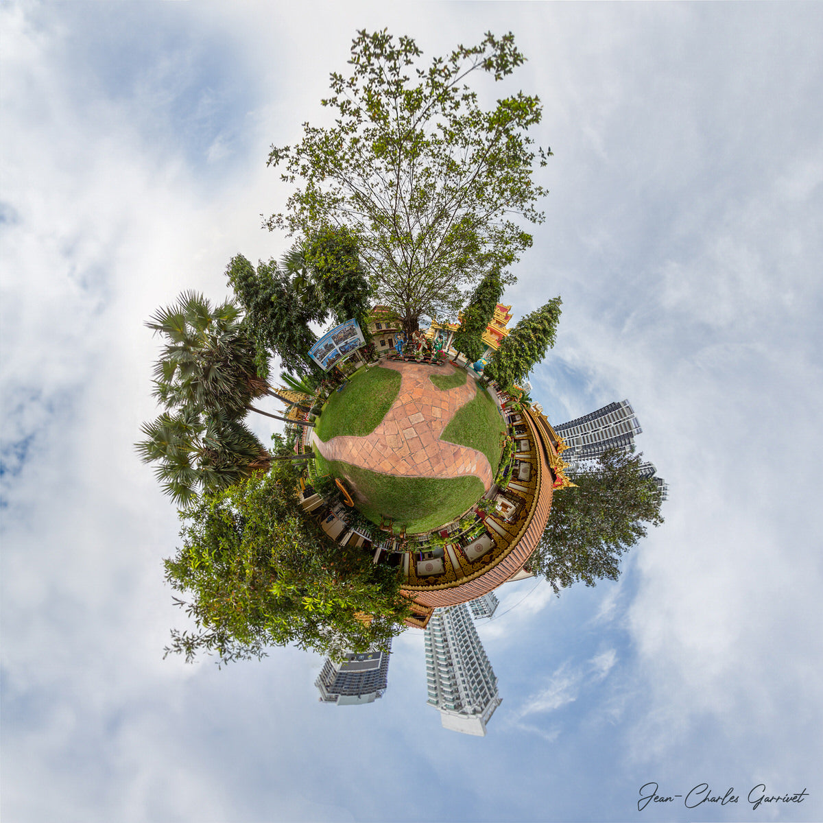 360-degree view of a park with trees and buildings, creating a miniature planet effect.